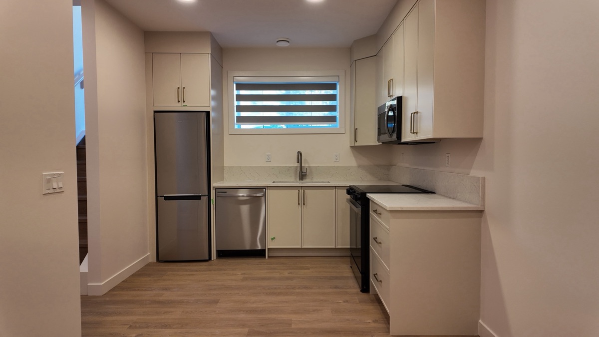 Suite kitchen with fridge, dishwasher, range and microwave.
